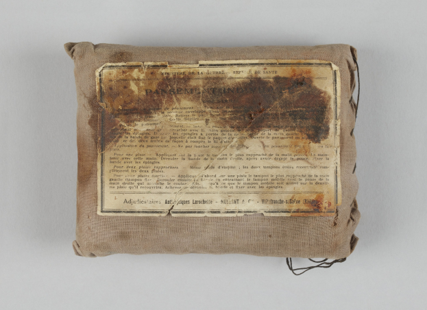 Kleiner Verbandskoffer mit einem informativen Blatt Papier oben drauf.