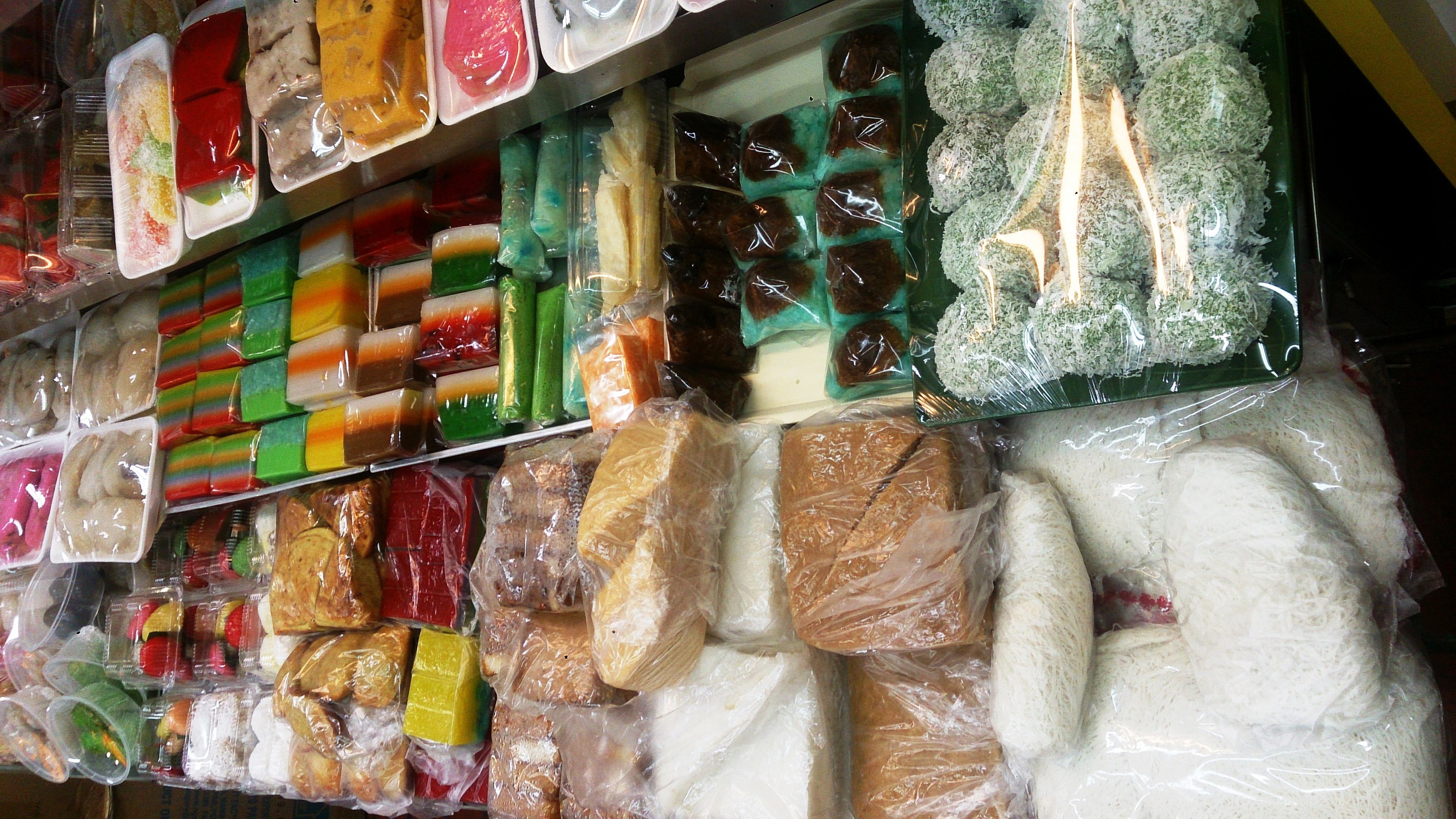 Ein Kühlregal in einem Lebensmittelladen, das mit verschiedenen verpackten Lebensmitteln in Polyethylenhüllen gefüllt ist.
