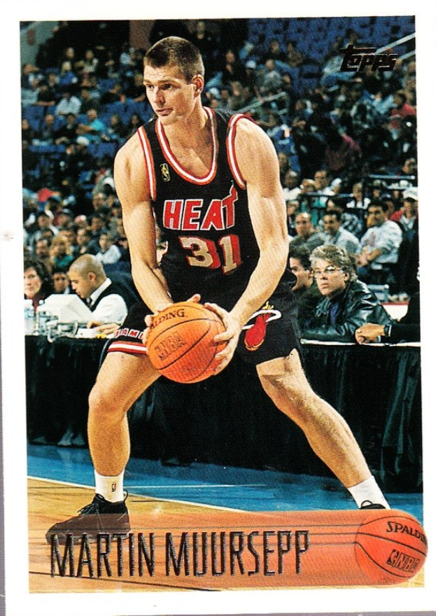 Ein Schwarz-Weiß-Foto von Martin Muirsepp, einem ehemaligen Spieler der Miami Heat, der einen Basketball hält, mit Menschen auf Stühlen und einem Tisch mit Gegenständen im Hintergrund und dem Text "1991-92 Topps Basketball Card" unten.