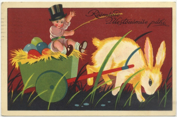 Eine alte Postkarte mit einem Baby in einem Zylinder, das einen Karren voller bunter Ostereier schiebt, zusammen mit einem Hasen, mit handgeschriebener Text, der einen fröhlichen Ostersonntag wünscht.