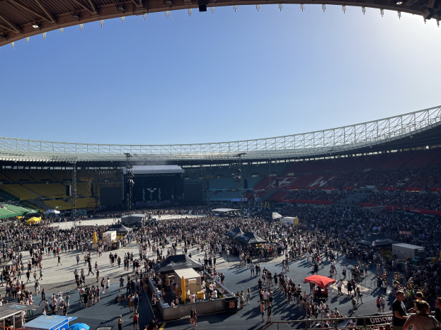 Eine große Menschenmenge versammelt sich vor einem Stadion mit Zelten und Absperrungen und wartet auf das WM-Event 2014.