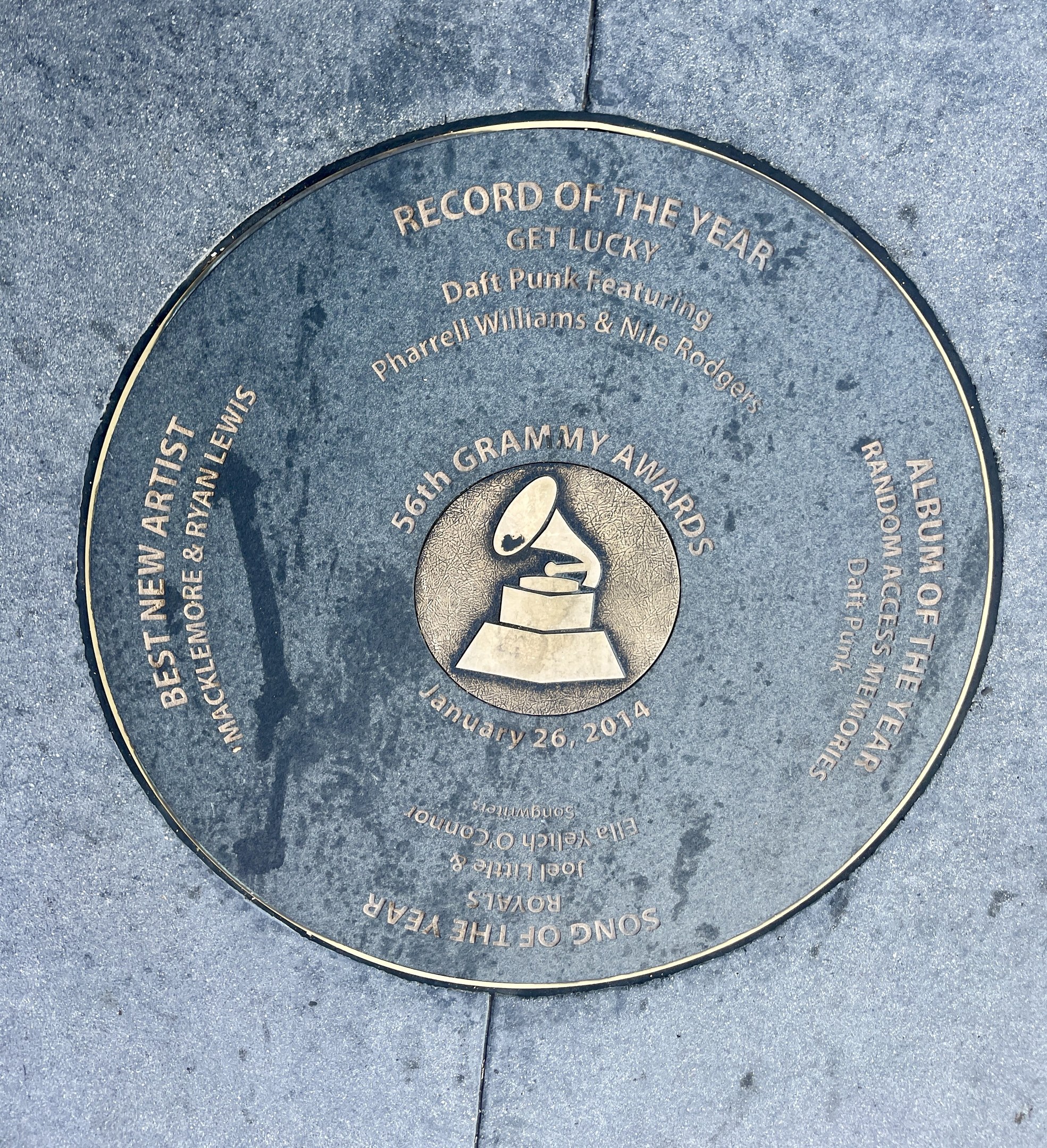 Ein kreisförmiges Hollywood Walk of Fame-Schild, das in den Boden eingelassen ist und Text und ein Bild enthält, als 'Aufnahme des Jahres' verliehen.