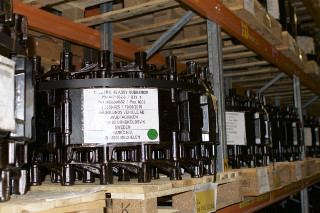 Ein Lagerraum voller metallener Objekte auf Holzpaletten, jeweils mit einem Aufkleber versehen, die Teil eines Verteilergehäuses zu sein scheinen, mit verschiedenen sichtbaren Komponenten.