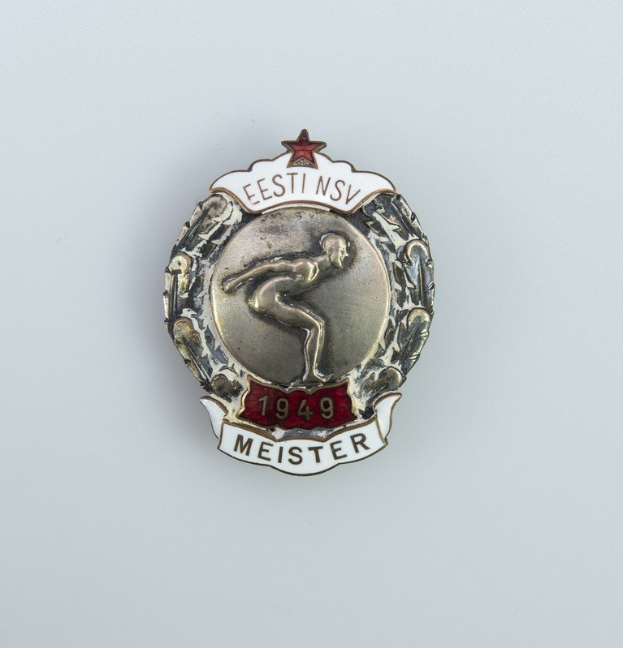 Silberner Button mit einem roten Stern, der den Emblem der Olympischen Spiele 1949 in Deutschland darstellt.