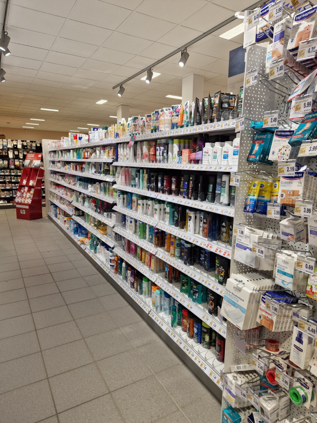 Apothekengang mit verschiedenen Medikamenten in Regalen.