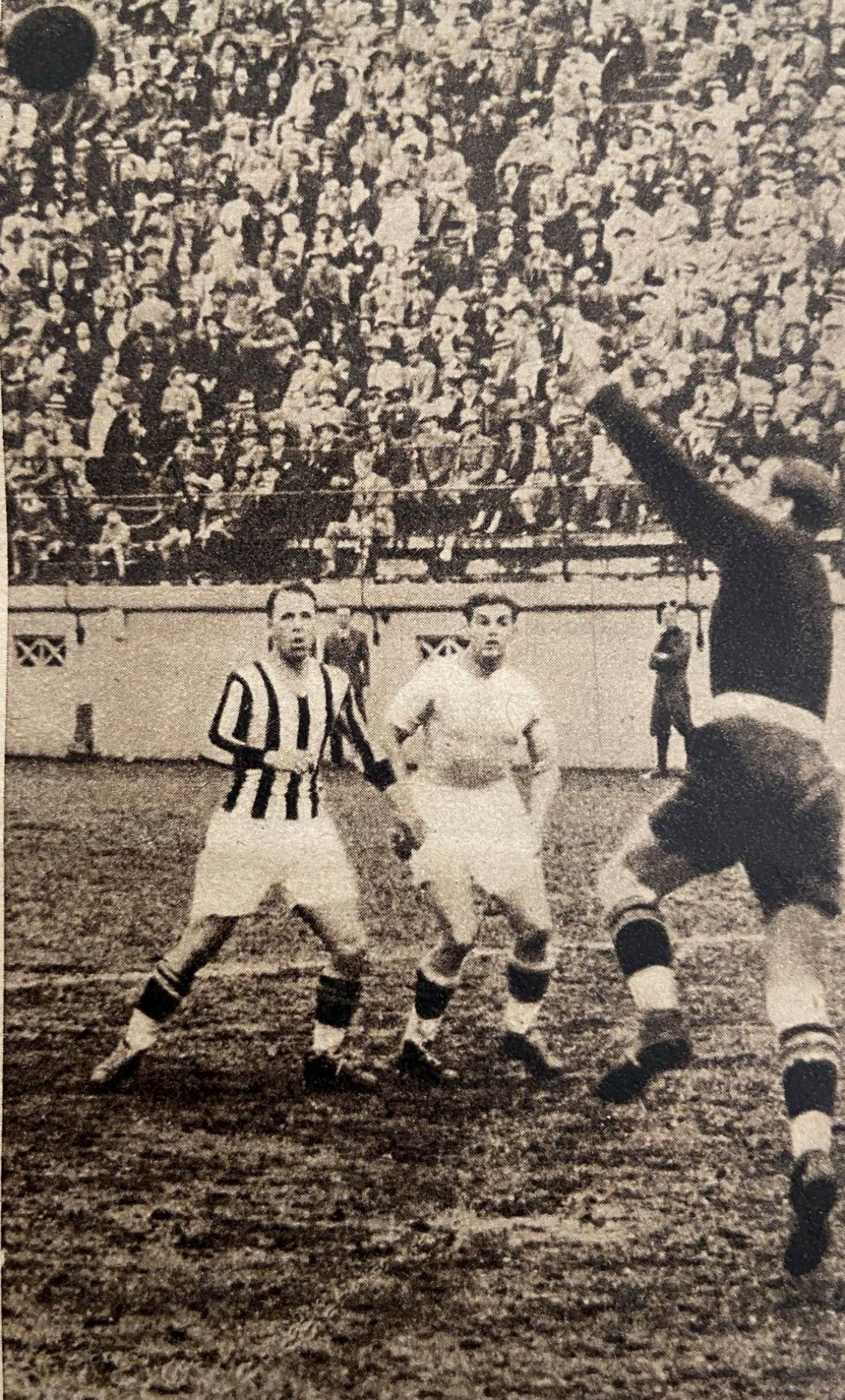 Schwarzes und weißes Foto von Männern, die Fußball spielen, mit Zuschauern auf den Tribünen und einer Wand im Hintergrund, beschriftet mit "Newcastle United v West Bromwich Albion".