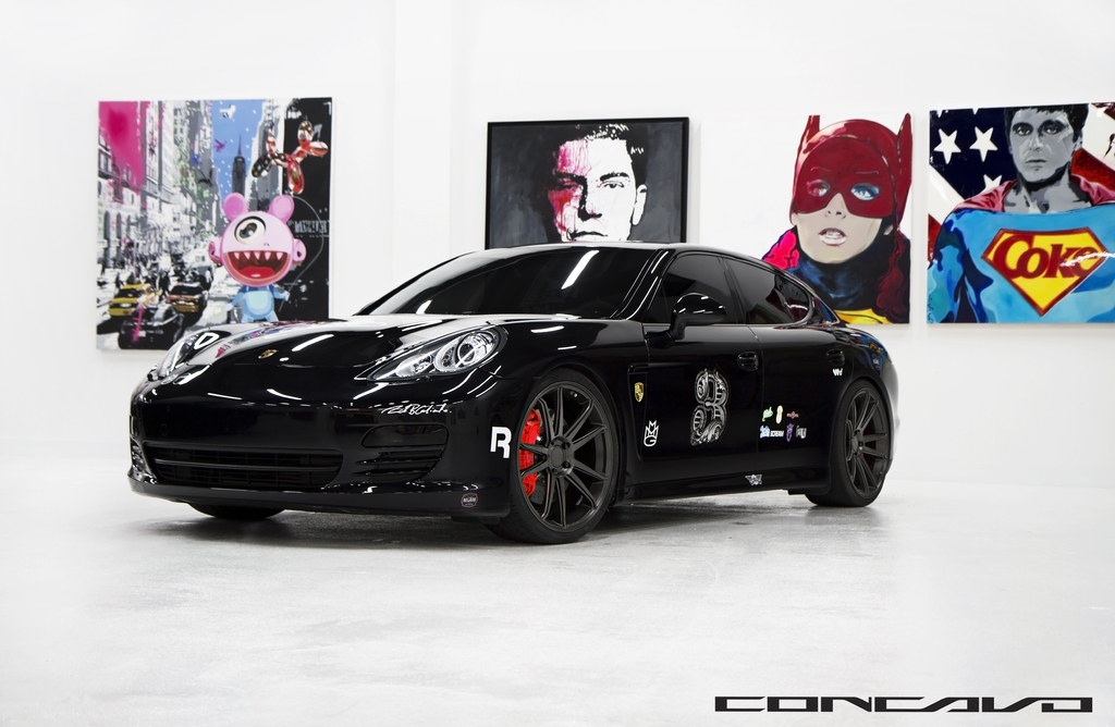 Ein schwarzer Nissan-Sportwagen mit Cartoon-Plakaten im Hintergrund und einer kleinen Inschrift unten.